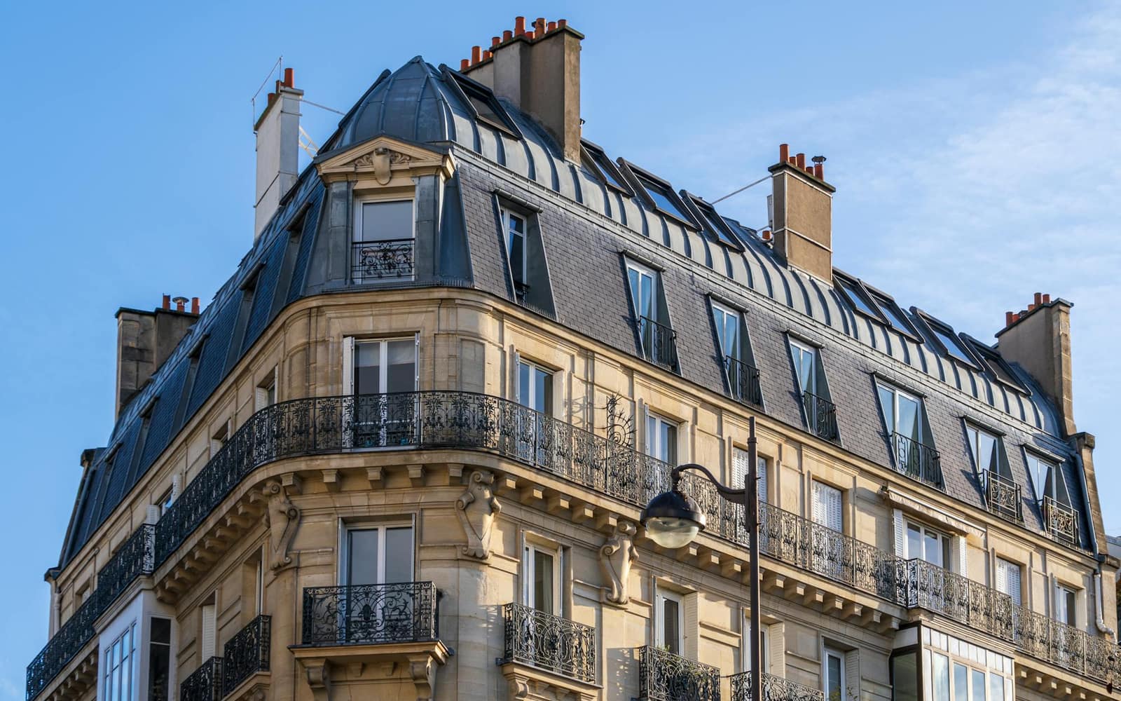 Façade haussmannienne parisienne — pierre de taille et toiture en zinc, le type de bâti qu'ERGIM rénove à Paris.